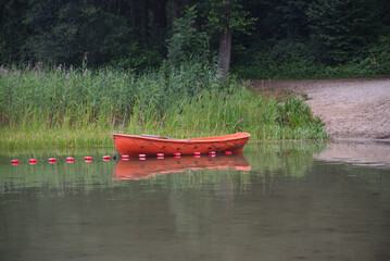 Łódka ratownika na brzegu jeziora - obrazy, fototapety, plakaty