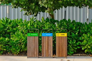 Selbstklebende Fototapete Abu Dhabi Modern wooden garbage bins for separate waste collection in public city park in Abu Dhabi,UAE. Urban ecology. Environmental care.
