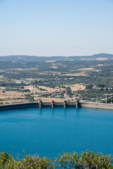 Fototapeta premium Large blue reservoir and distant hydro-electric dam