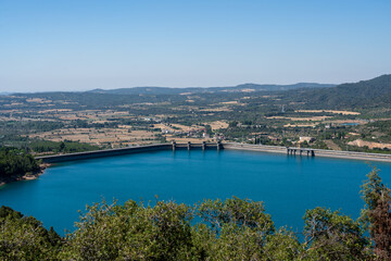 Large blue reservoir and distant hydro-electric dam