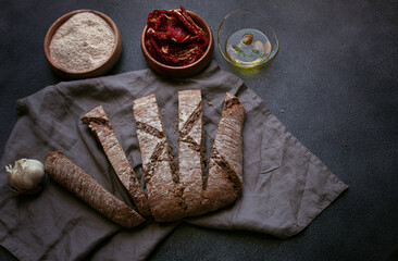 Homemade organic bread. dried tomatoes and bread. Made with wholemeal and nuts. olive oil and green olives.