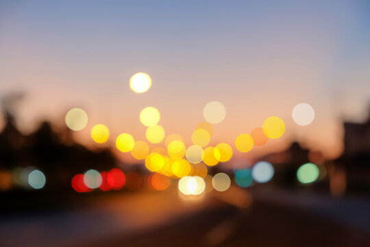 bokeh street light of traveling cars in the evening sunset.