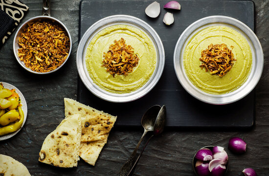Arabic cuisine, Egyptian fava beans and herbs dip ( Bessara). It contains fava beans, onion, garlic and fresh herbs. Served with crispy fried onions,bread,pickles and fresh onios.