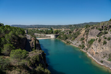 Fototapeta na wymiar spillway below El Grado Dam, Hydro-Electricity Generation, Huesca, Spain, a concrete hydro-electric reservoir dam, clear blue sky