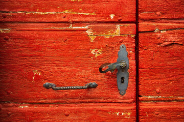 Vintage red wooden door with old iron handle