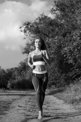 Blonde runner woman runs in the park joggin barefoot, black and white picture