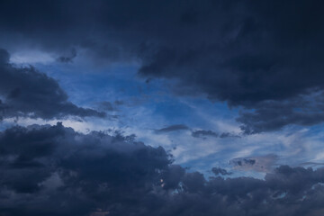 Fototapeta na wymiar Epic Dramatic storm dark grey cumulus rain clouds against blue sky background texture, thunderstorm
