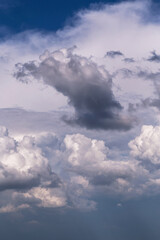 Epic Dramatic storm dark grey and white cumulus rain clouds against blue sky background texture, thunderstorm