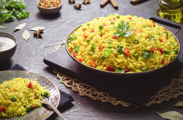 Arabic cuisine; Traditional Arabic Basmati rice with vegetables. Served with tomato and yogurt sauce, crispy fried onions, golden roasted nuts and raisins. Close up with copy space.