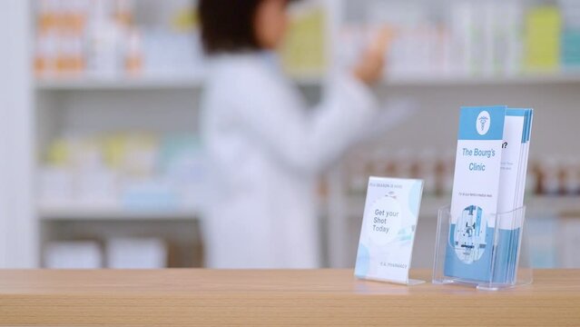 Information leaflet on health care at a modern drug store or pharmacy with blurry background. Pharmacist packing medication on shelves of prescription pills at a clinic, ready to prescribe and assist