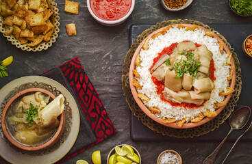 Arabic cuisine; Egyptian oriental Fattah with white rice and crispy bread topped with seasoned garlic red sauce and chunks of cow's trotters. Served with traditional cow's trotters soup.