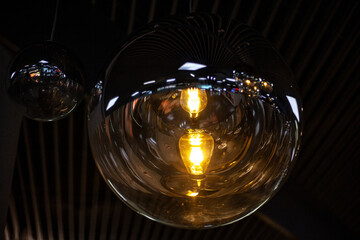 Fancy lamps on the ceiling. Glowing balls. Indoor lighting design. Spherical transparent containers for diffusing light.