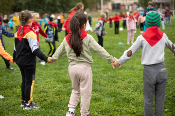 Fototapeta premium Children hold hands forming circle. Children at festival in summer. Schoolchildren study in nature.