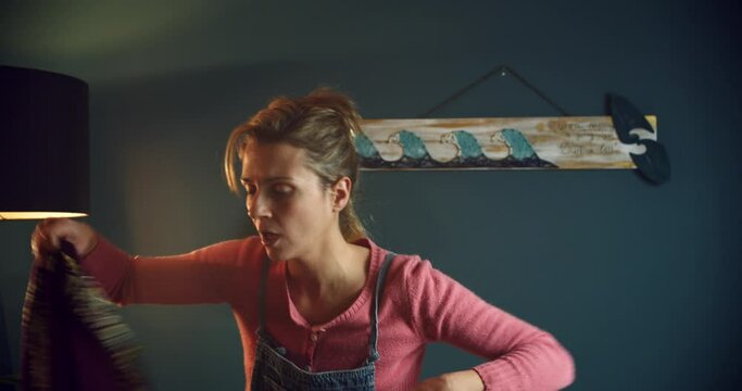 Woman entering home, taking her shawl of and speaking funny to someone.