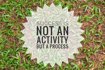 the word success is not an activity but a process with a grass background. Selective focus