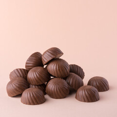 heap of chocolate candy or sweets, on lighter background, closeup