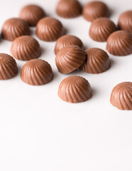 chocolate candy or sweets scatter on white surface, taken in shallow depth of field with space for text