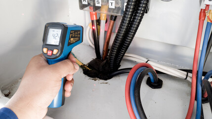temperature measurement on the main power cable of the electrical panel using a digital infrared thermometer, to detect overcurrent, check the temperature of the cable.