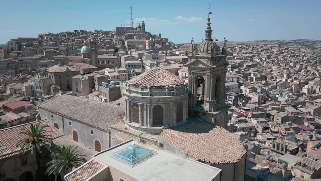 alt flying counter clockwise around old church with Caltagirone passing in bkrd