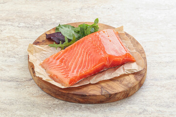 Raw salmon fillet over board