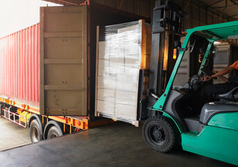 Forklift Tractor Loading Packaging Boxes into Shipping Container. Trucks Loading Dock Warehouse....