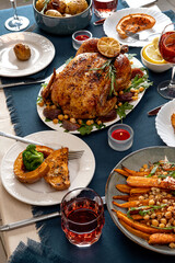 Traditional holiday dinner for celebration Thanksgiving. Baked chicken, potatoes and sides. Family party or gathering. Fall table setting. Top view table scene