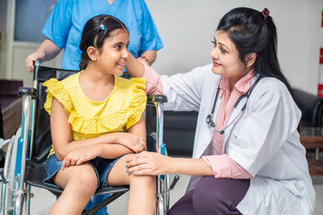 Indian doctor support disabled girl child patient sit on wheelchair at hospital, Children healthcare concept.