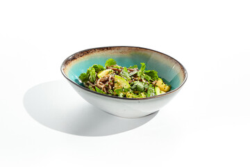 Healthy pasta soba with green vegetables. Vegetarian dish - soba with zucchini, broccoli and green pea on ceramic bowl. Veggie food handmade bowl isolated on white background. Plant based bowl dining.