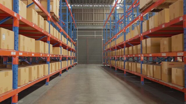 interior of large logistics distribution warehouse. Cardboard box of products with label on shelf rack in a row at factory. Storage awaiting for shipping, delivery. Business warehouse industry concept