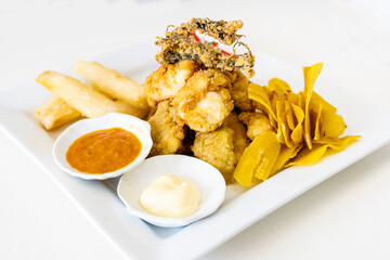 Peruvian food: chicharron de pescado or fish cracklings with fried cassava and onion salad with...