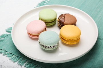 macaroons of different colors on a white plate. 