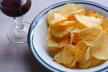 赤ワインのグラスと、ボウルに盛ったポテトチップス