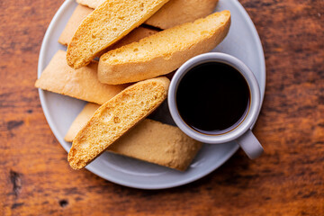 Sweet anicini cookies. Italian biscotti with anise flavor and coffee cup on wooden table.