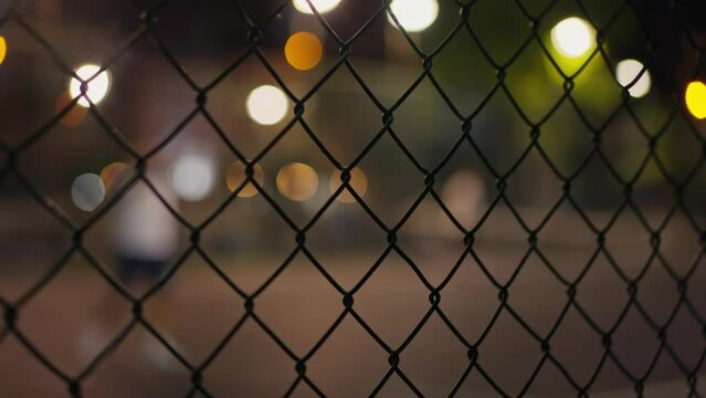Through grid portrait of paddle tennis man playing on court outdoors. One caucasian padle player sportman hitting the ball. High quality 4k footage