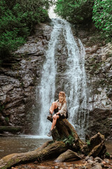Fototapeta na wymiar Travel. Girl travels through the mountains and waterfalls of wild nature. Unity, mental health, eco travel. Hiking in the mountains, van life vibes, travelling,good moments, digital detox