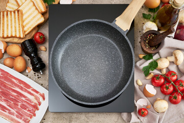 Making fried eggs and bacon - frying pan on induction hob and ingredients at domestic kitchen