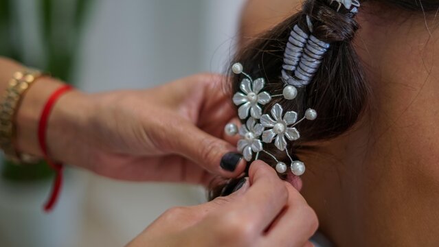 Primer plano del arreglo del pelo de una novia con una trenza y adornos celtas, en casa de la novia