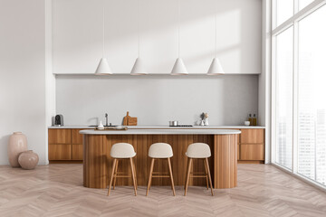 Light kitchen interior with island and seats, kitchenware and panoramic window