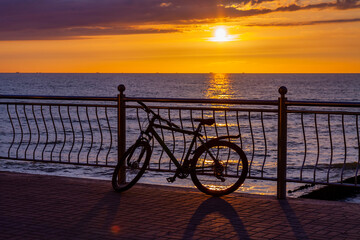 Scenic sunset sea landscape.  dramatic sky and horizon at sunset time, bike at the embankment