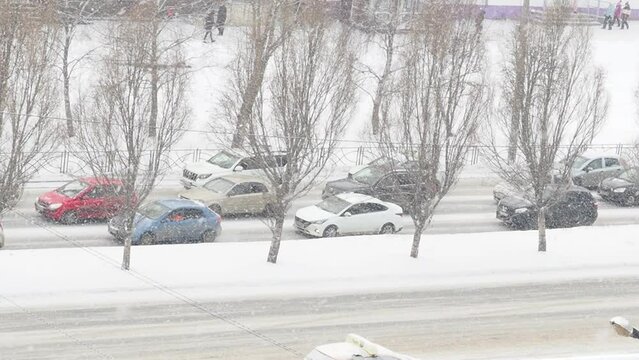 Snow falling down over the city. heavy snowfall and blizzard in the city. snowy road. cars driving in the snow
