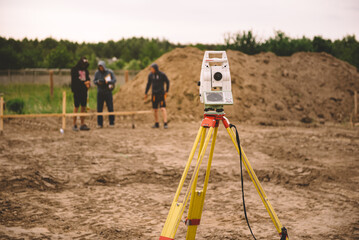Surveyor equipment - GPS system or theodolite total positioning system outdoors at house construction site. Surveyor engineering with total station before house building