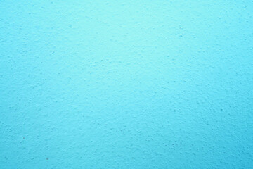 abstract, rough plaster wall texture is light blue for backgroun