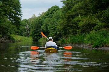 People in kayaks on water during kayaking in nature reserve 