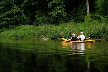 Fototapeta na wymiar People in kayaks on water during kayaking in nature reserve 