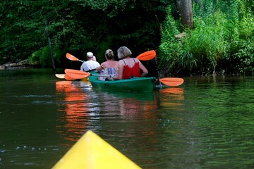 People in kayaks on water during kayaking in nature reserve "Refuge of beavers on the Pasleka river" in Warmia and Mazury, Poland