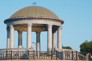 Rotunda on the embankment. Summer morning. Blue sky.