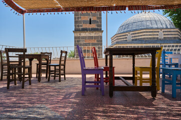 empty wooden chairs and tables at the roof Sheikh Matar Mosque and  dubbed the Four-legged Minaret  in Diyarbakir, Turkiye. Local name is seyh matar cami ve dort ayakli minare.