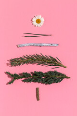 Obraz na płótnie Canvas Handmade Xmas tree made of fir twigs and daisy. Christmas background.