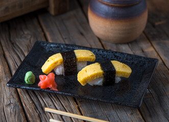 TAMAGO authentic nigiri served in a dish isolated on wooden background side view of authentic nigiri