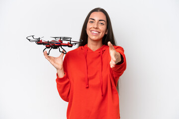 Young caucasian woman holding a drone isolated on white background shaking hands for closing a good deal - Powered by Adobe